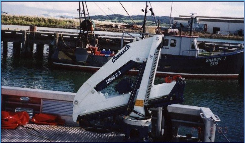 Knuckle boom marine crane mounted on a work vessel in harbor